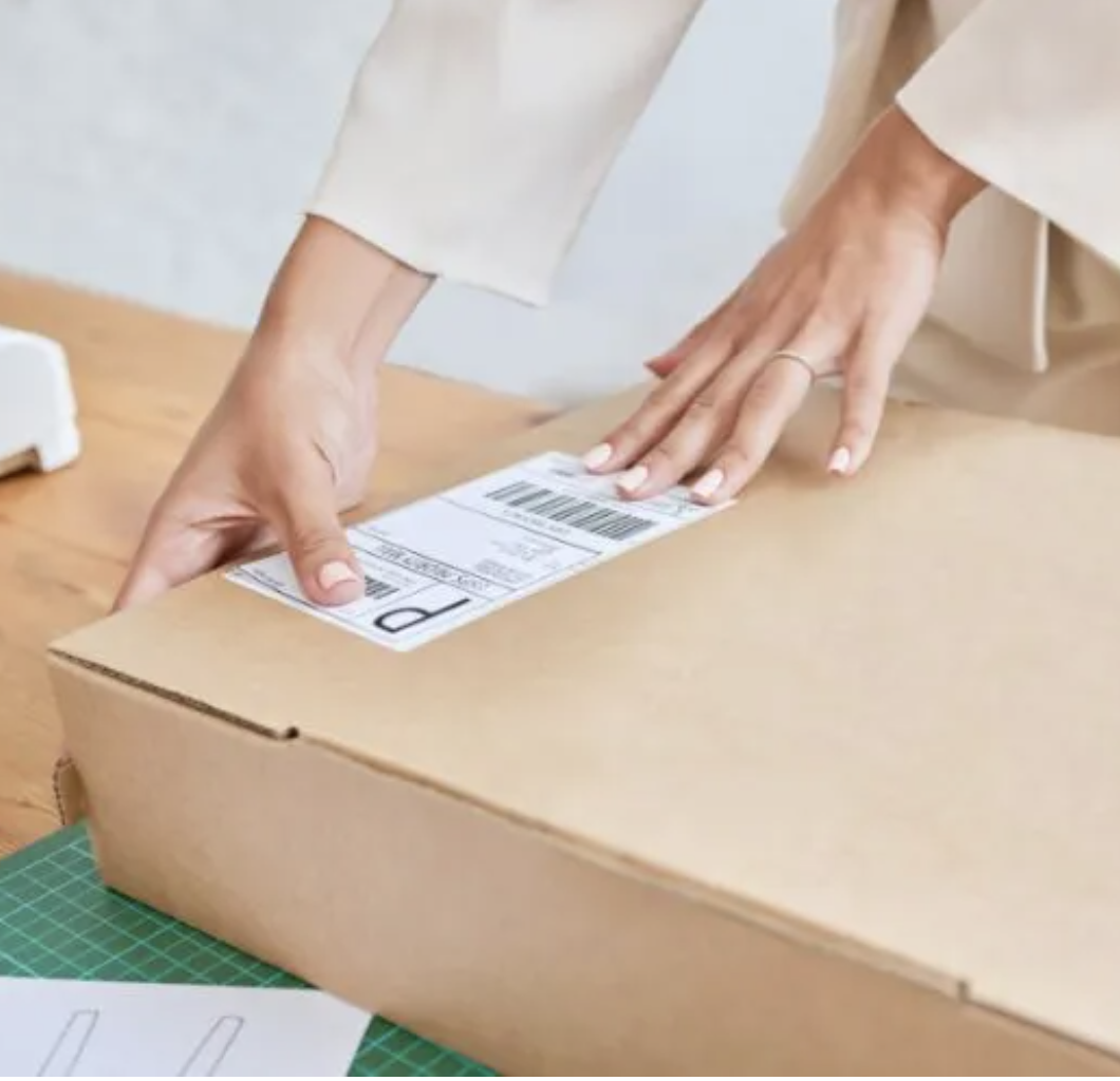 Person placing return label on shipping box